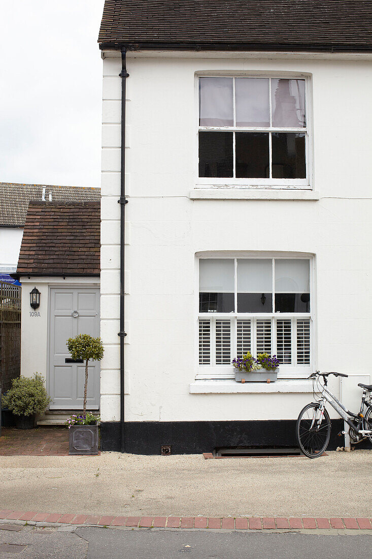 Bicycle and whitewashed facade of semi-detached home UK