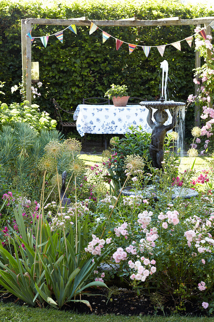 Wasserfontäne und Fähnchen im Garten eines Hauses in Wiltshire, England, Vereinigtes Königreich