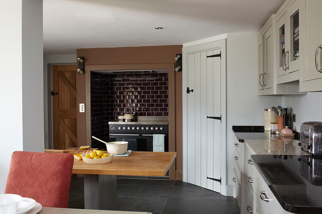 Einbaubackofen und Küchentisch in einer umgebauten Scheune in Somerset, England, UK