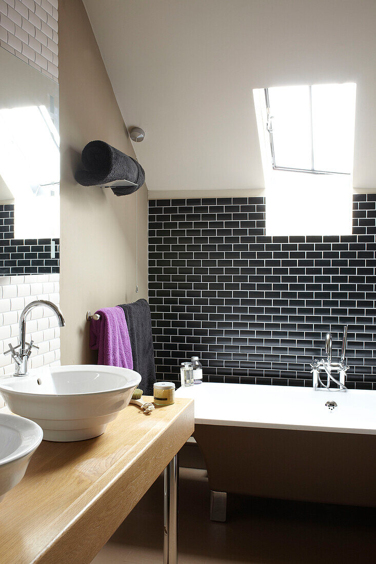 Black tiled attic bathroom in Somerset barn conversion England UK