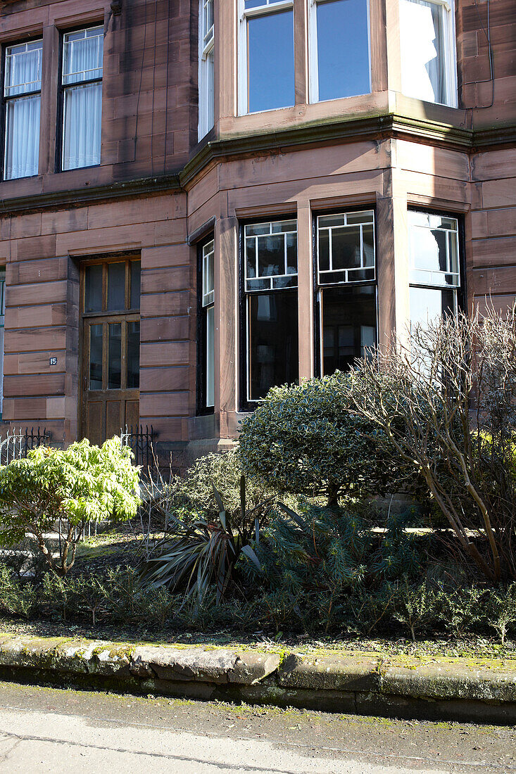 Erkerfenster und Vorgarten eines schottischen Mehrfamilienhauses UK