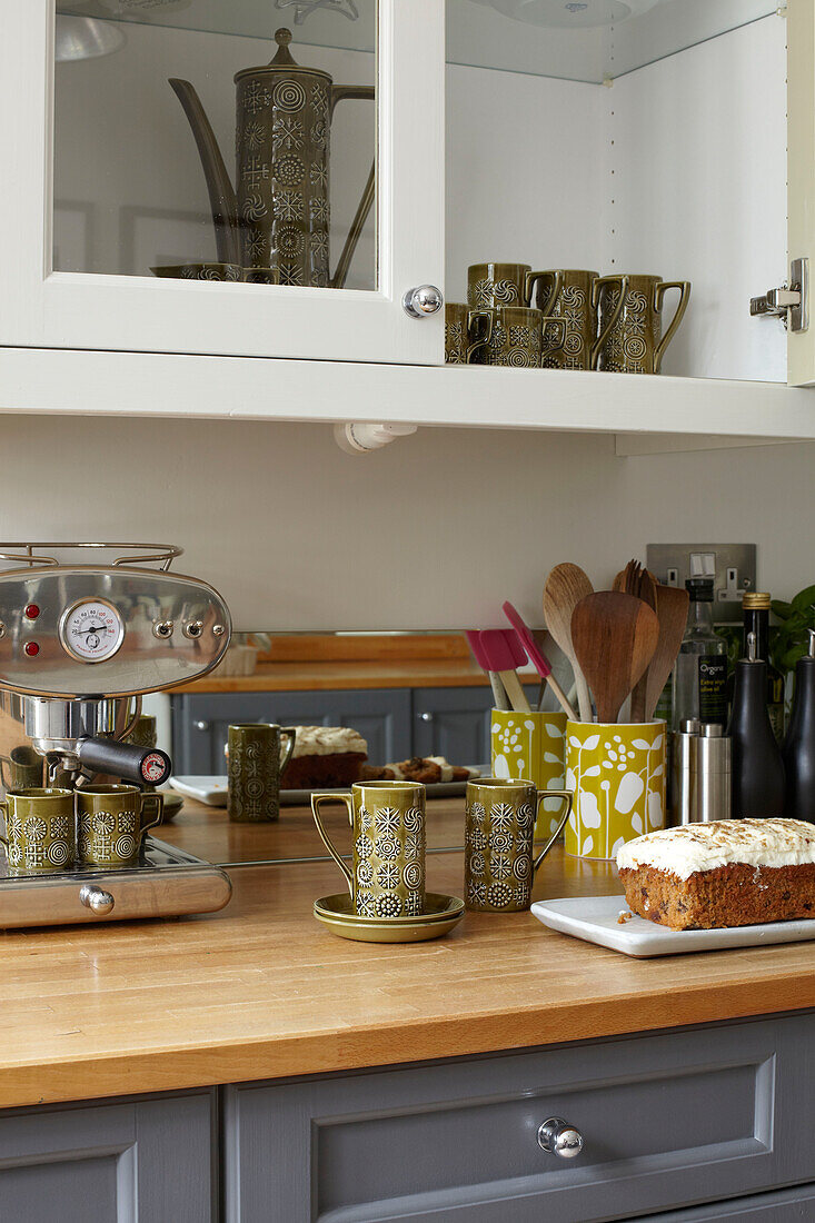 Kaffeegeschirr und Karottenkuchen auf der Arbeitsfläche in der Küche von Coombe cottage, UK