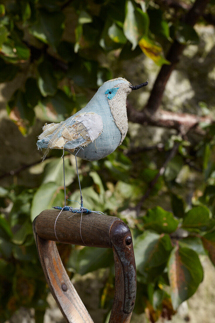 Handgefertigter Vogel aus Stoff auf einem Spatenstiel im ummauerten Garten, St Lawrence, Isle of Wight, UK
