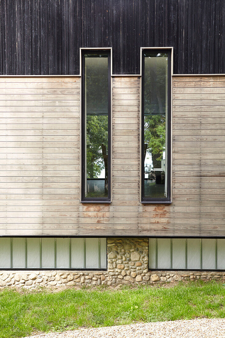 Moderne Fassade mit Holzverkleidung und Kieselsteinverkleidung im unteren Geschoss Isle of Wight, UK