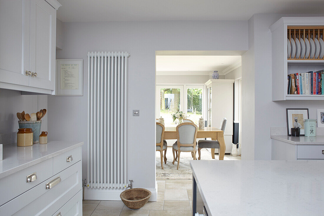 Blick durch die Tür von der Küche mit wandmontiertem Heizkörper und Tellerregal zum Esszimmer Buckinghamshire UK
