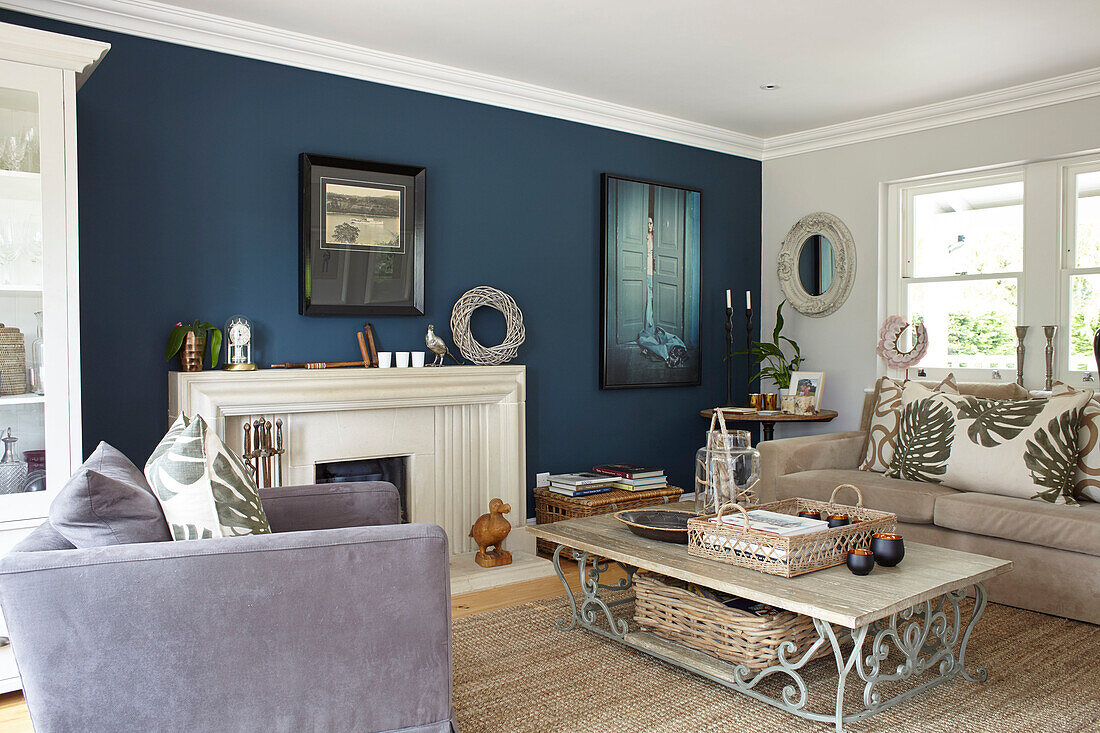 Niedriger Couchtisch mit Kissen mit Palmenmuster und natürlichen Texturen im Wohnzimmer in Hague Blue, Buckinghamshire, UK