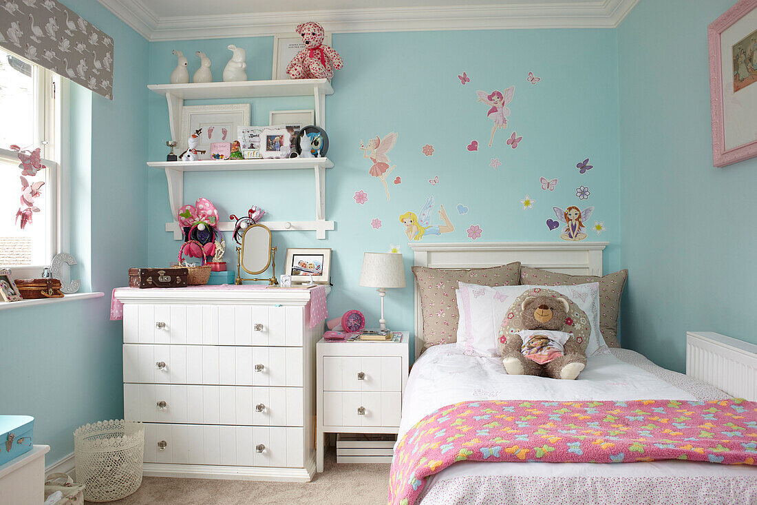 Wandregal und Kommode am Bett mit Spielzeug in einem Mädchenzimmer mit dem Anstrich ?Chance? Buckinghamshire UK