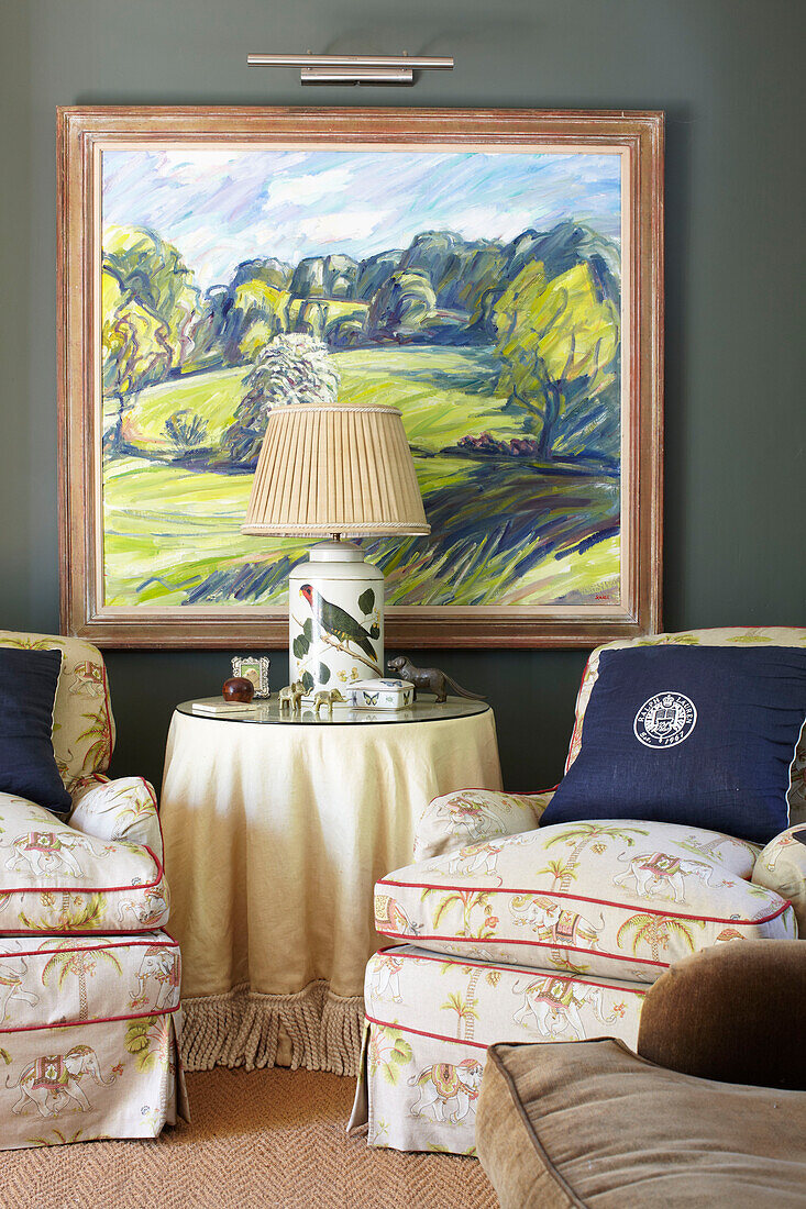 Pair of armchairs and artwork in living room of Wiltshire country home, England, UK