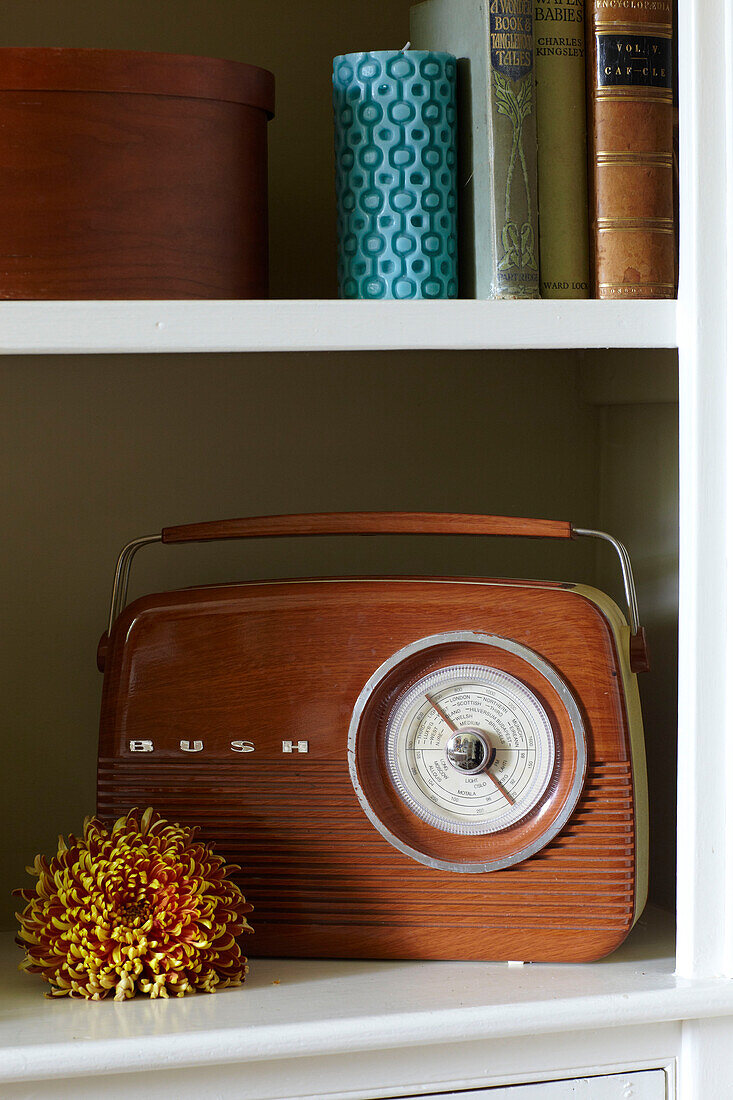 Radio and ornament with books on shelf in East Cowes home, Isle of Wight, UK