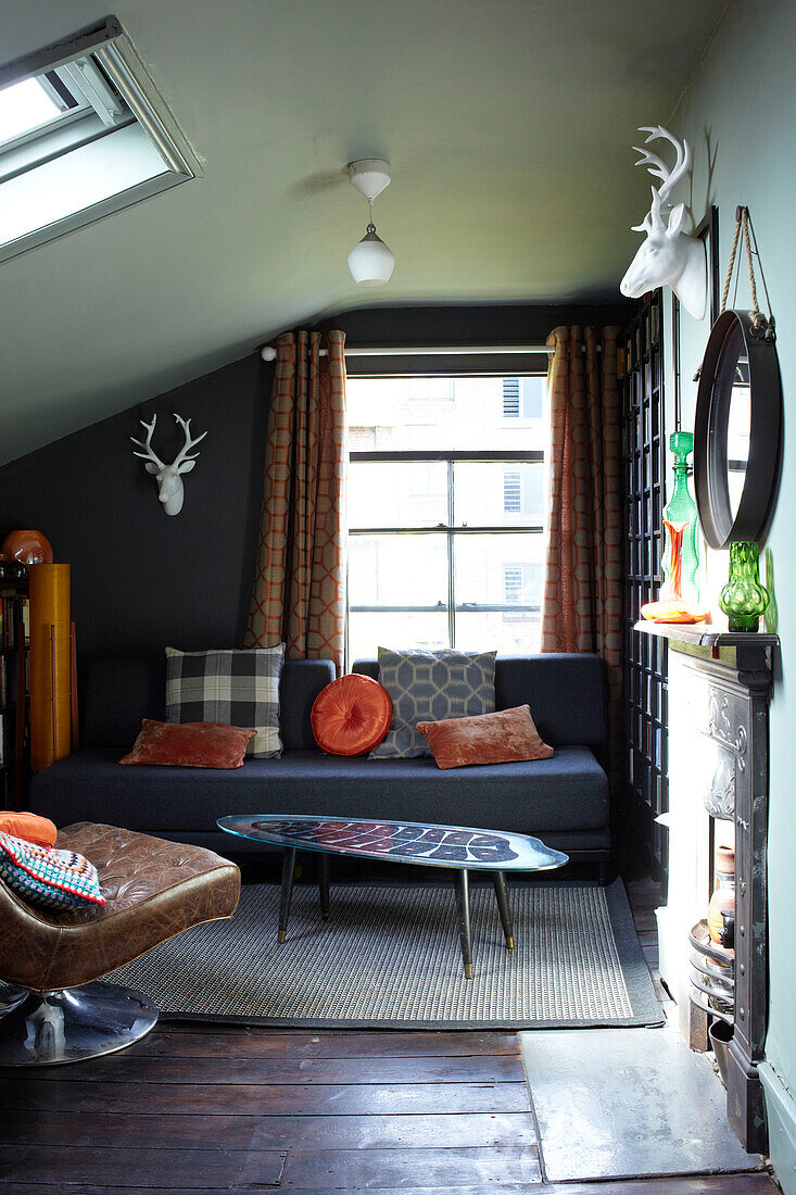 Brauner Ledersessel mit Sofa in einem umgebauten Dachgeschoss in London, England, Vereinigtes Königreich