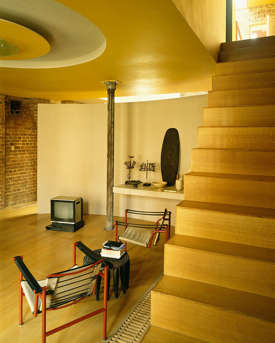 Offenes Wohnzimmer mit offener Treppe und einem Paar Basculant-Stühle im Stil von Le Corbusier