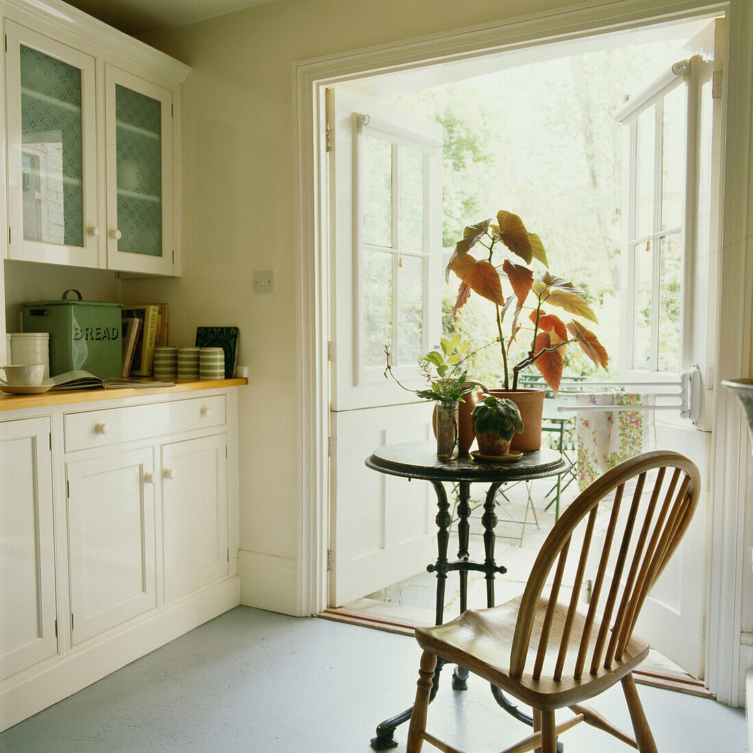 Bemalte Holzküchenzeile im Landhausstil mit offener Glastür zum Garten