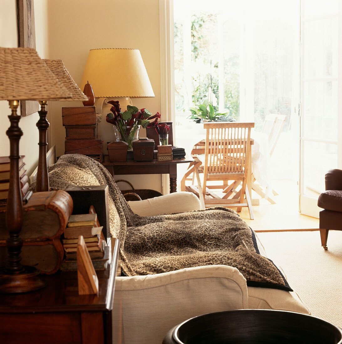Wohnzimmer mit cremefarbenem Dekor und passenden Möbeln und Blick auf den Wintergarten