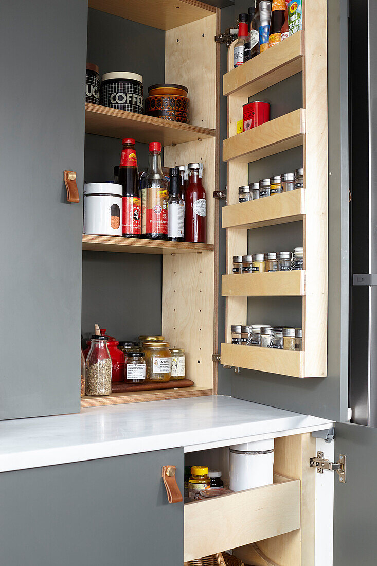 Bespoke larder fitted inside cupboards in industrial-style kitchen renovation London UK