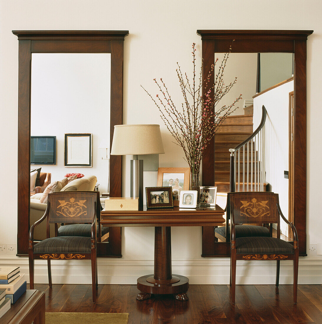 Pair of large mahogany mirrors on wall with Biedermeier chairs and console table