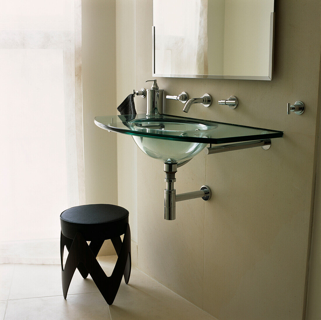 Badezimmer aus Kalkstein mit Glaswaschbecken und Chromarmaturen