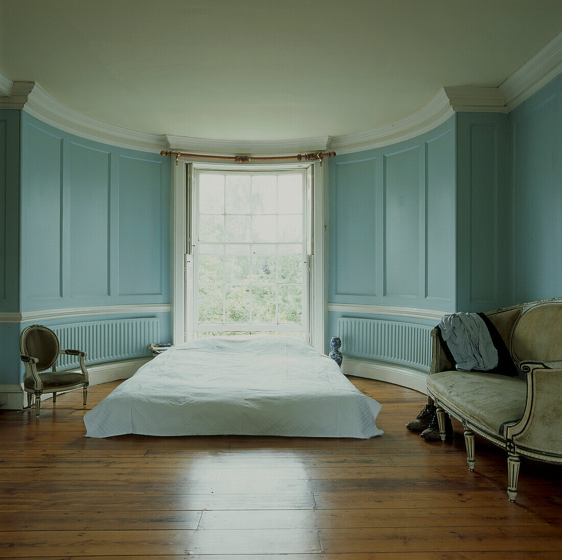 Schlafzimmer mit blau gestrichener Vertäfelung