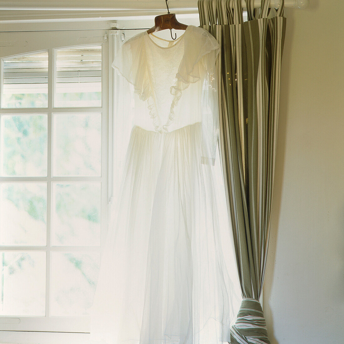 Fenster mit weißem Kleid und Vorhängen