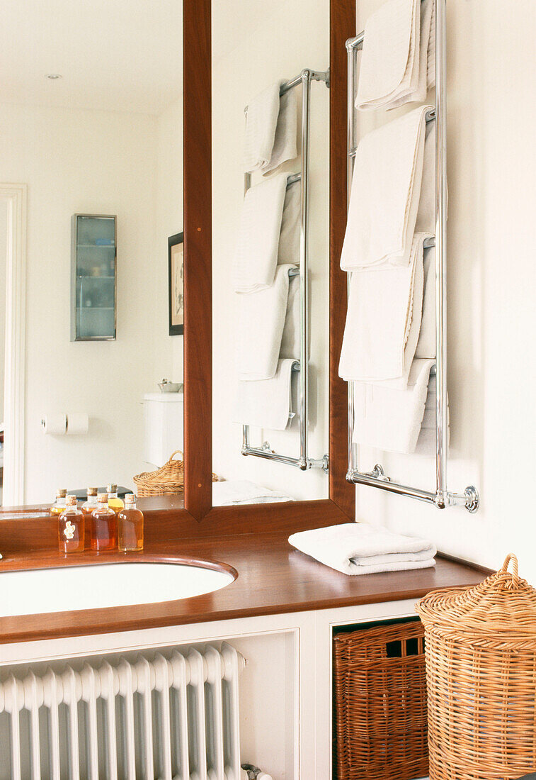 Bathroom mirror corner detail with heated towel rail and wooden surround