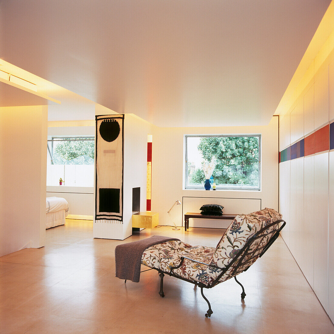 Moderner, offener Wohnbereich mit geblümtem Schlafsofa und Raumbeleuchtung hinter der Zwischendecke