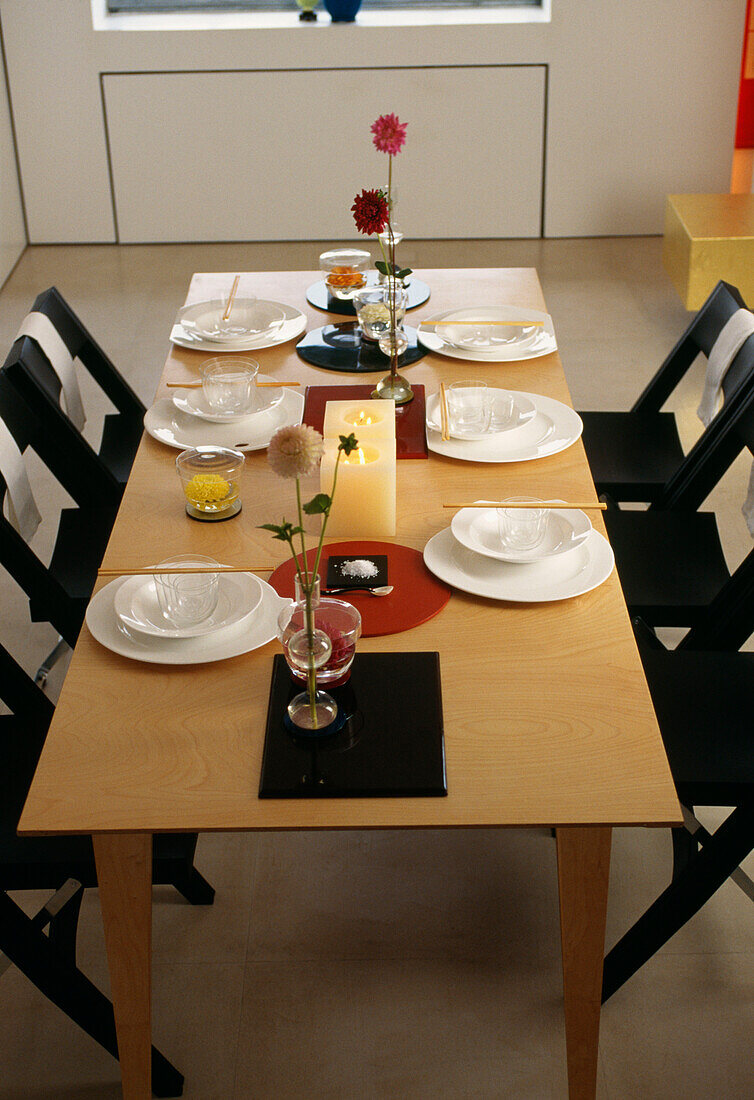 Gedeckter Tisch das Mittagessen mit Servietten und schwarzen Klappstühlen und Servietten im Esszimmer (Detailaufnahme)