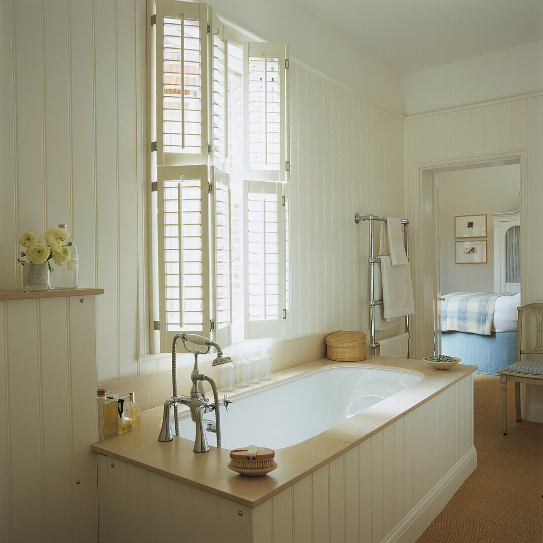 Weiß getäfeltes Badezimmer mit hölzernen Fensterläden