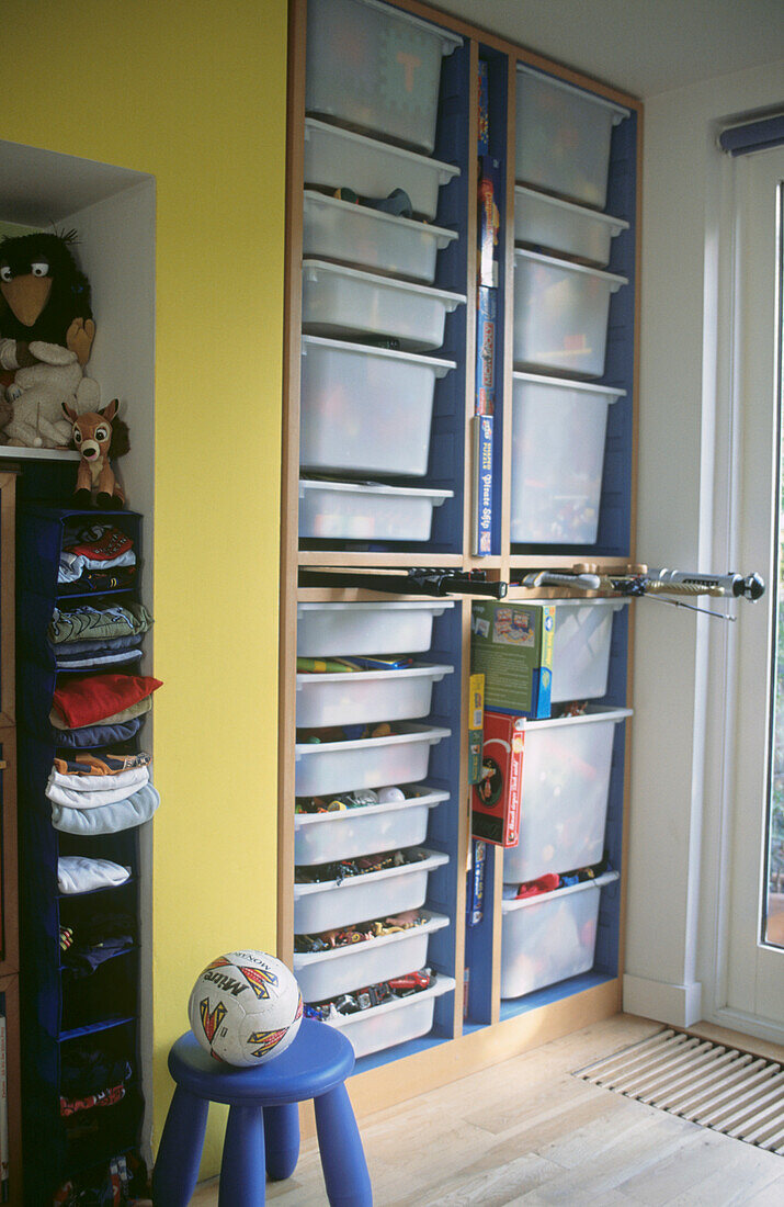 Custom built storage unit with plastic containers in child's bedroom