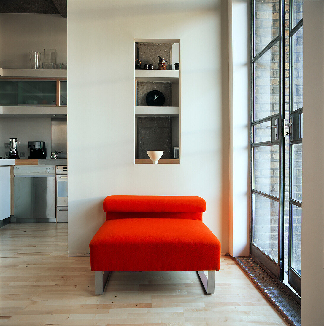 Red upholstered low chair with kitchen 