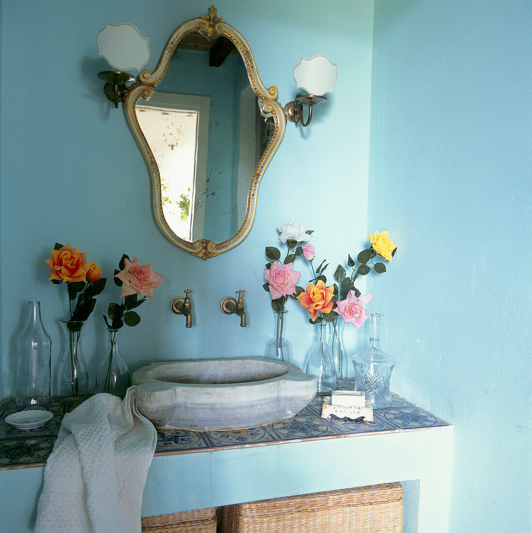 Buntes türkisfarbenes Badezimmer mit Waschbecken und vergoldetem Spiegel