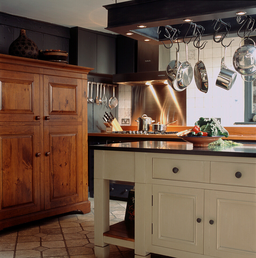 Recessed lighting set in bespoke saucepan rack in centre of traditional style kitchen