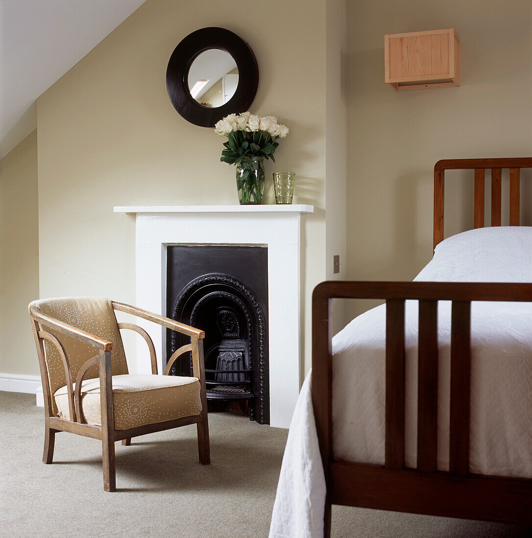 Minimalistisches Schlafzimmer im viktorianischen Stil mit Bett, Kamin und Stuhl