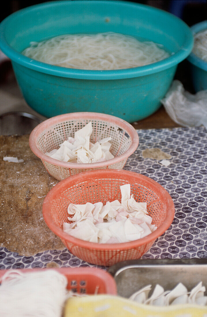 Bowls of freshly prepared won tons and noodles in a street market in Shanghai China