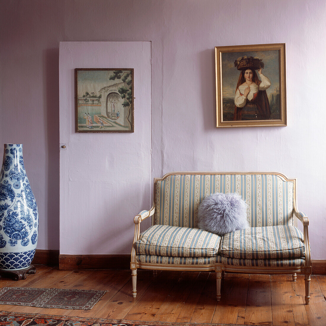 Antikes zartes Sofa in einem fliederfarben gestrichenen Schlafzimmer mit Holzfußboden