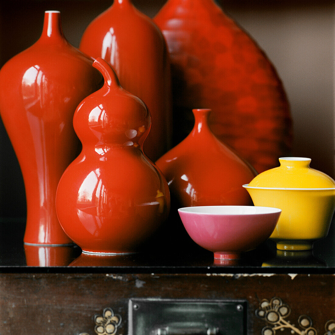 Präsentation von roten Keramikvasen und -gefäßen auf einem Tisch