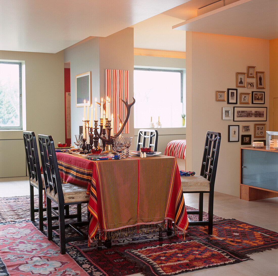 Mit friesischem Stoff bedeckter Esstisch mit Hirschhorn-Kandelabern und afrikanischen gedrechselten Kerzenhaltern in einem offenen Wohnbereich