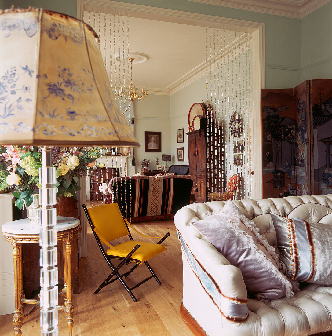 Double reception room in Victorian apartment with crystal room dividers and colourful furnishings