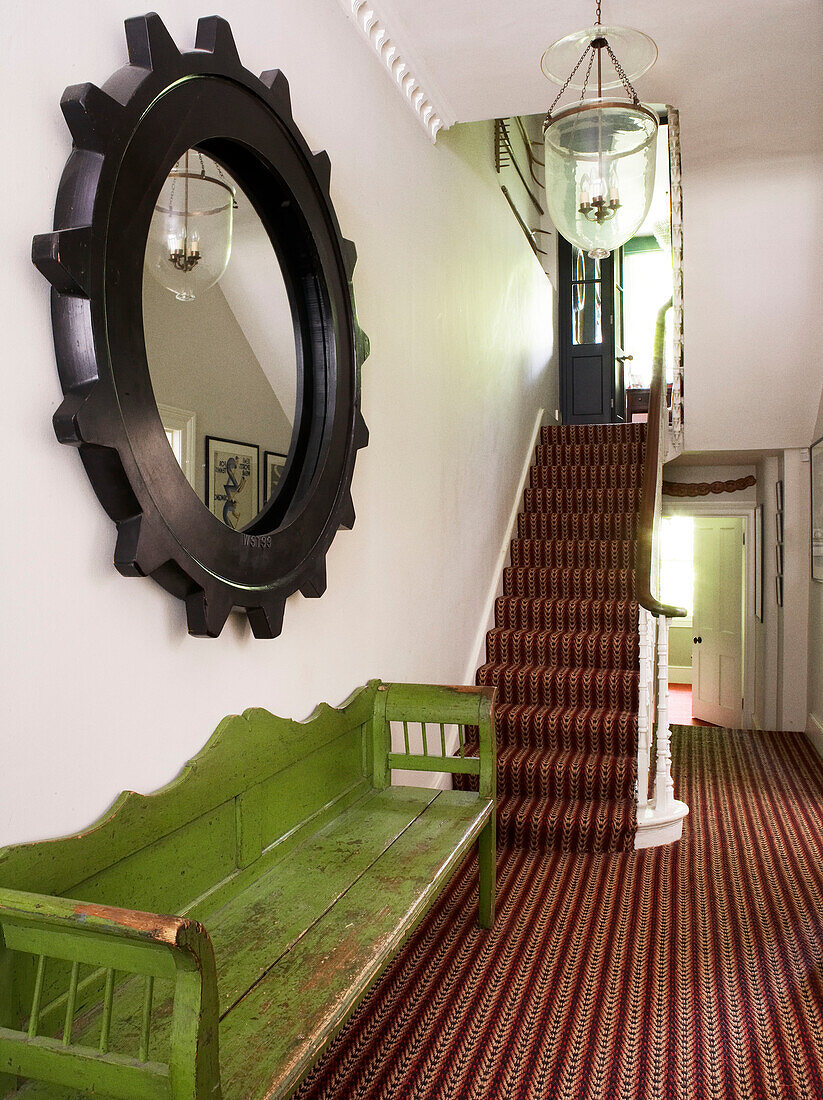 Hall stairs and landing with sisal carpet and weathered green bench