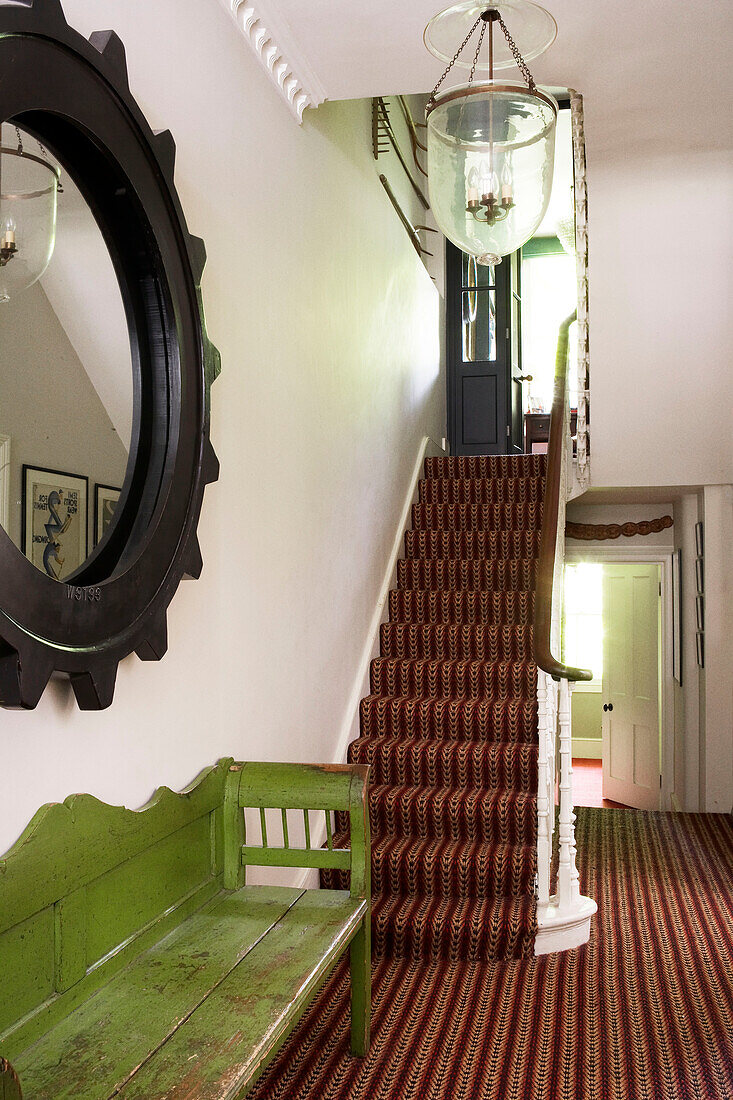 Flurtreppe und Treppenabsatz mit Sisalteppich und verwitterter grüner Bank