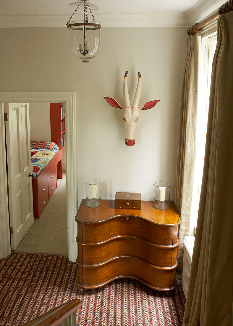 Treppenabsatz mit gestreiftem Sisalteppich und Blick durch die Tür ins Kinderzimmer
