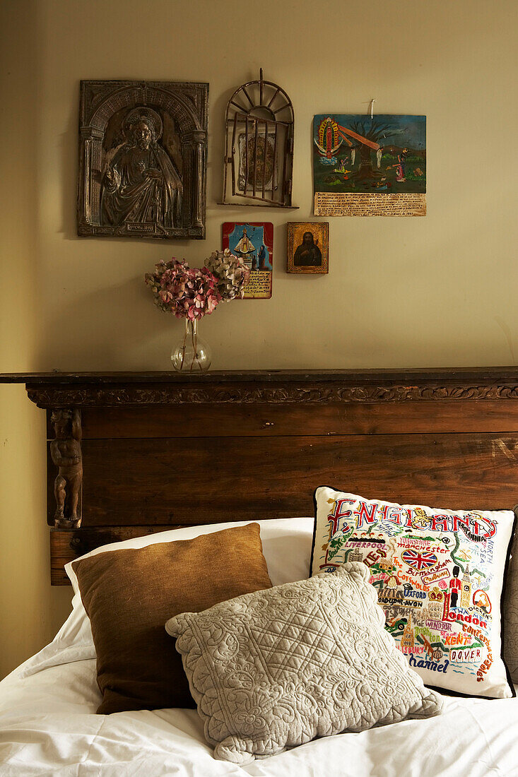 Doppelbett mit hängenden Ikonen über einem Vintage-Holzbettkopf