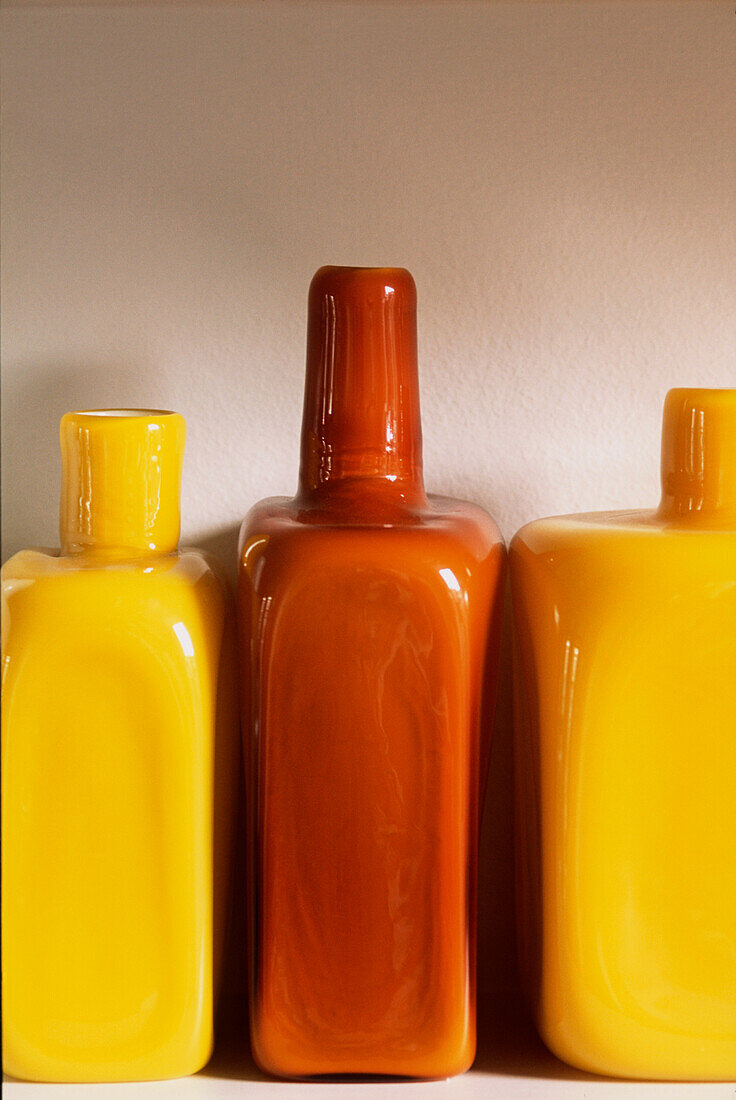Detail of yellow and brown coloured glass bottles or vases