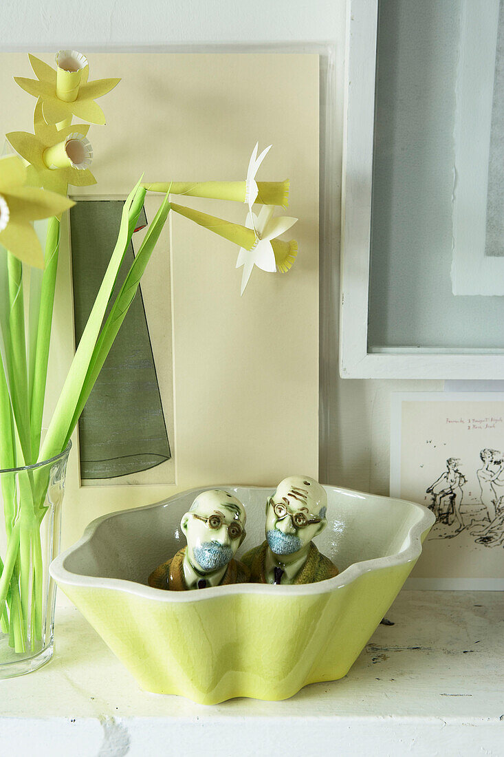 Still life with paper daffodils and busts in bowl