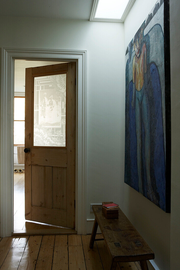 Large modern artwork under lightwell in hallway of London townhouse, UK