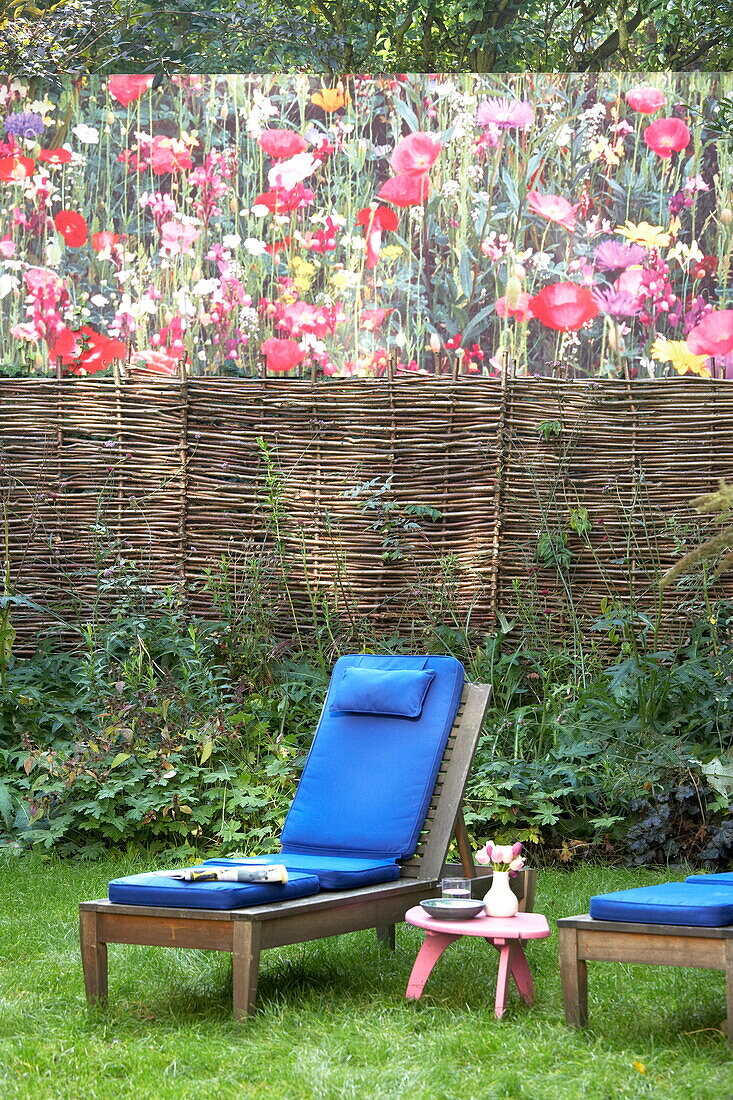 Blaue Liegekissen im Garten mit Weidenzaun und Kunstwerk, London, England, UK