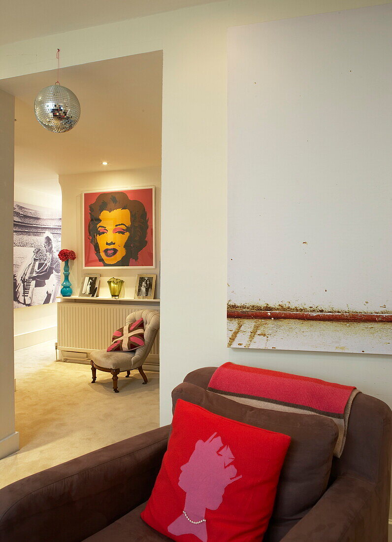Discokugel mit Kunstwerken und Kissen in einem flippigen Haus in London, England, Vereinigtes Königreich