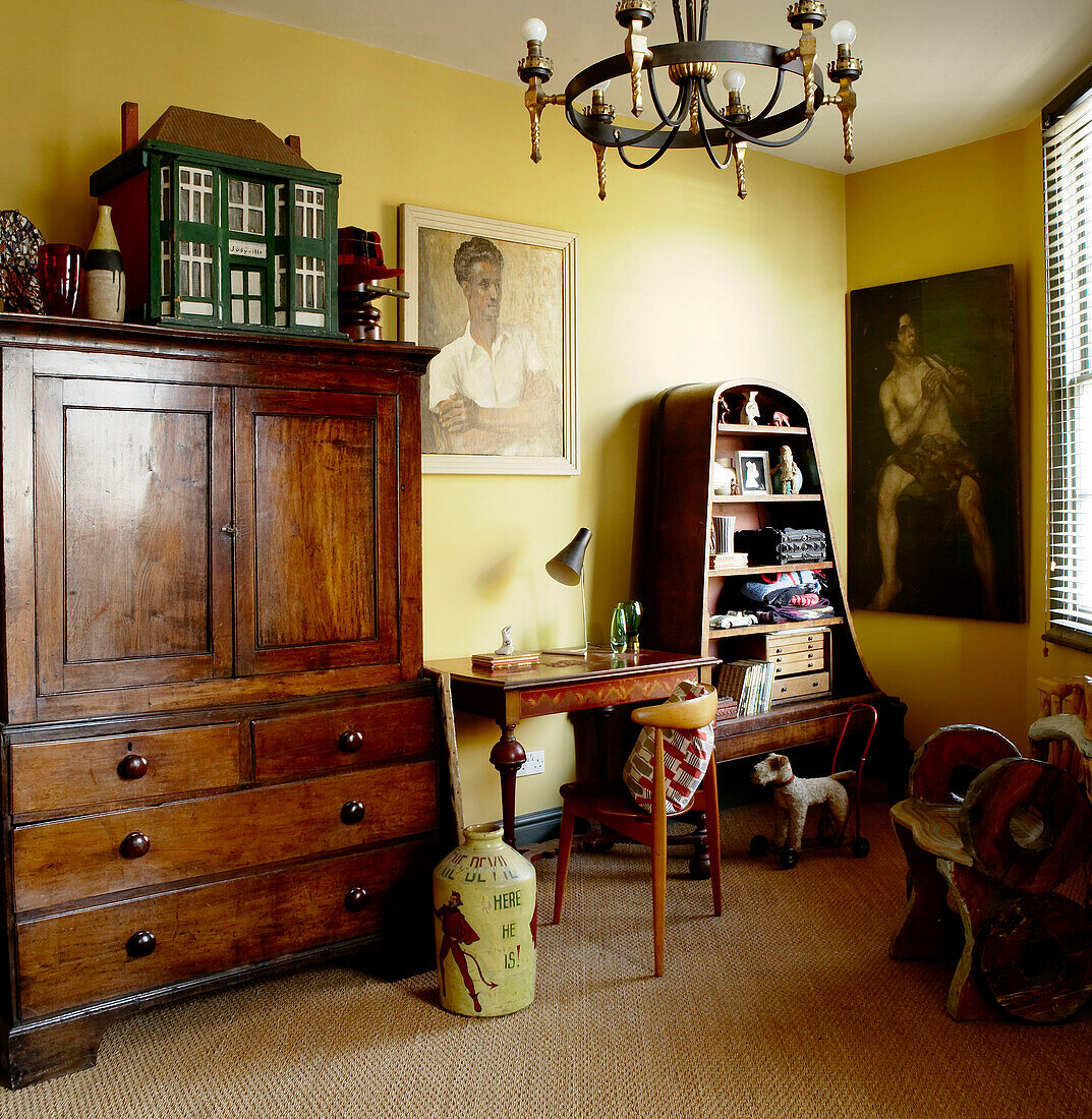 Gelbes Wohnzimmer mit Vintage Möbeln und einer interessanten Sammlung von Kunstwerken und Memorabilien
