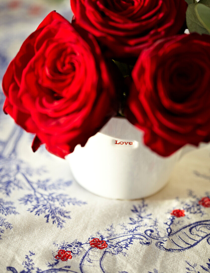 Red roses on an embroidered tablecloth