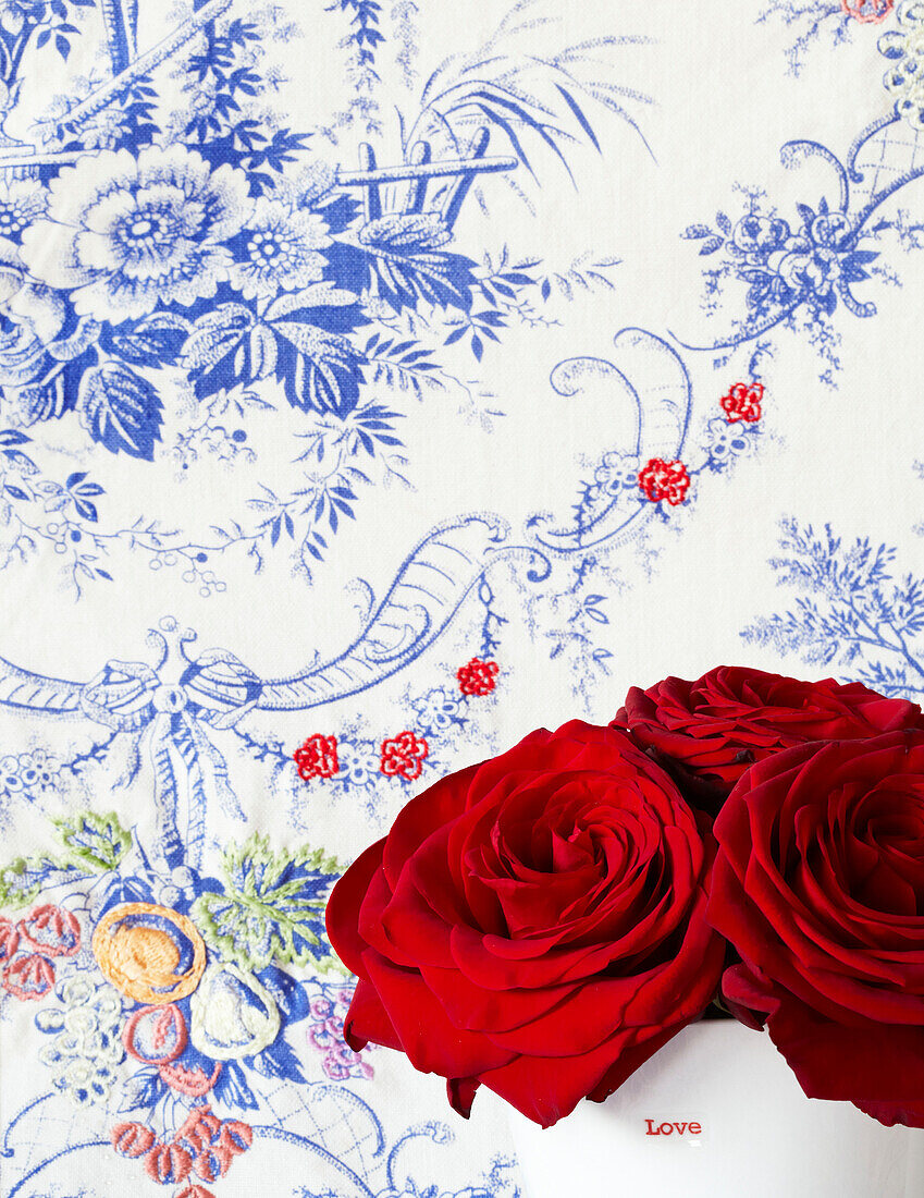 Rote Rosen und blaue Blumentapete