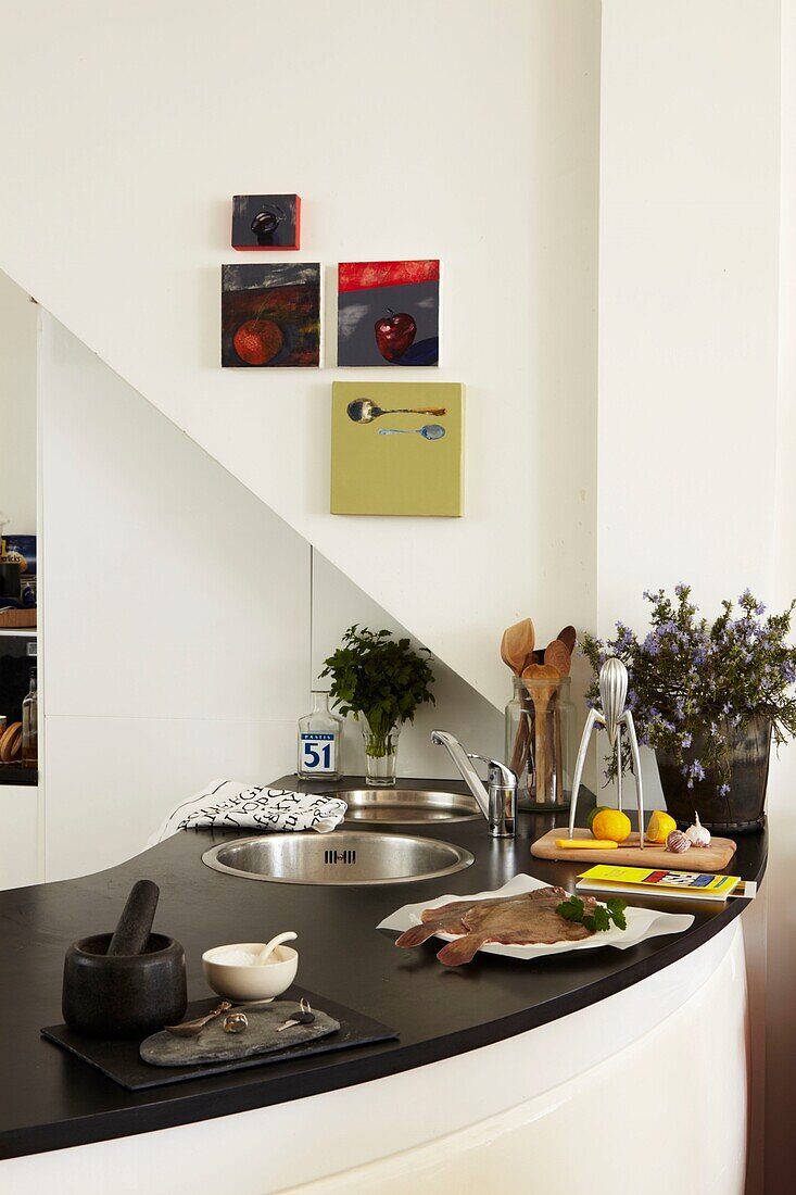 Küchenbereich mit schwarzer Arbeitsplatte und Fisch auf einem Teller