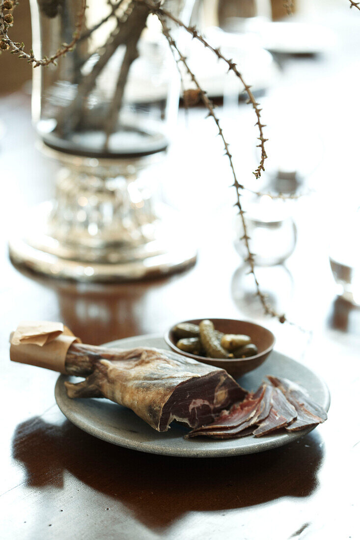 Getrocknetes Fleisch und Gewürzgurken auf dem Tisch in einem Haus in Zermatt, Schweiz